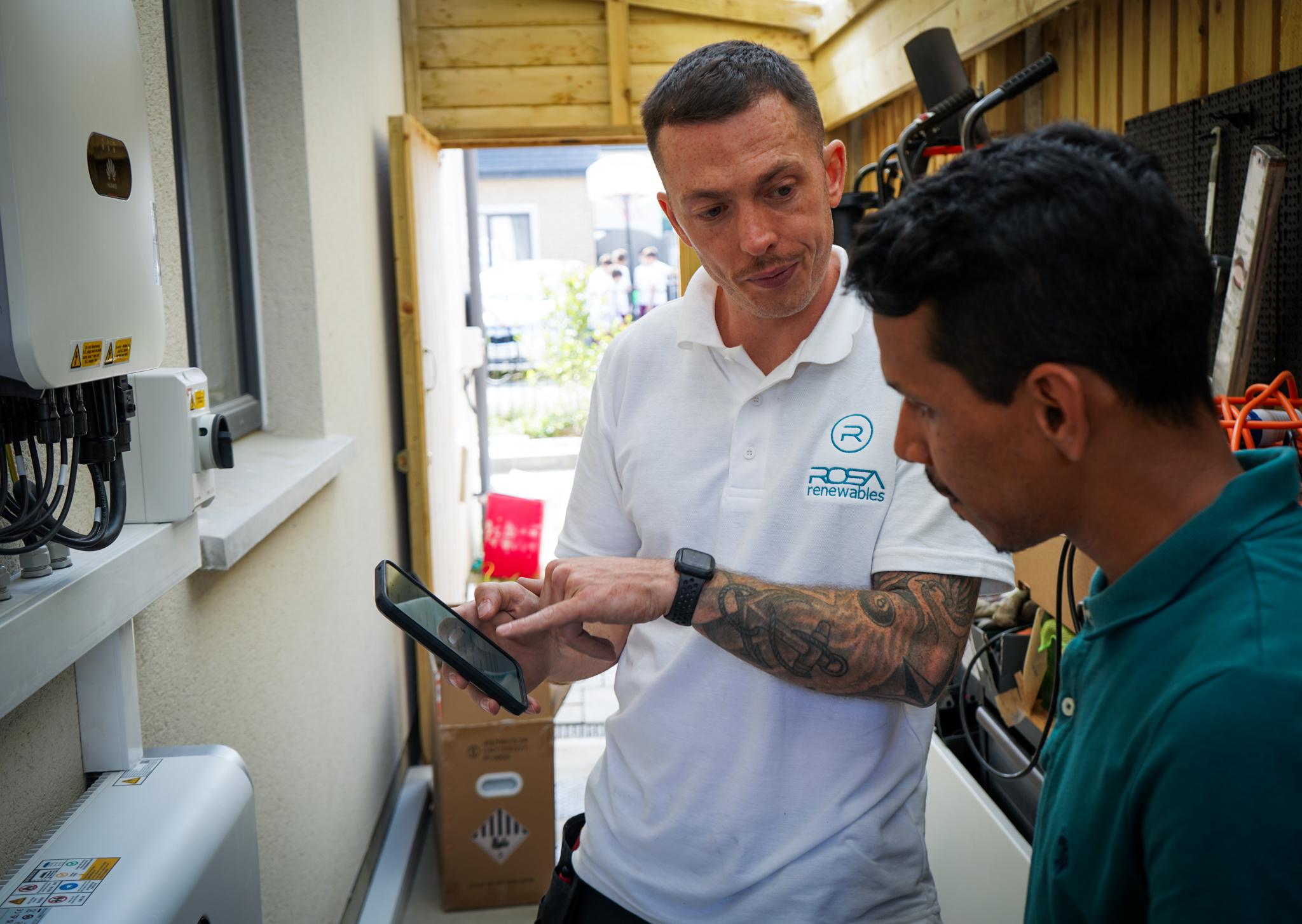 rosa renewables staff technician consulting energy grid on mobile device