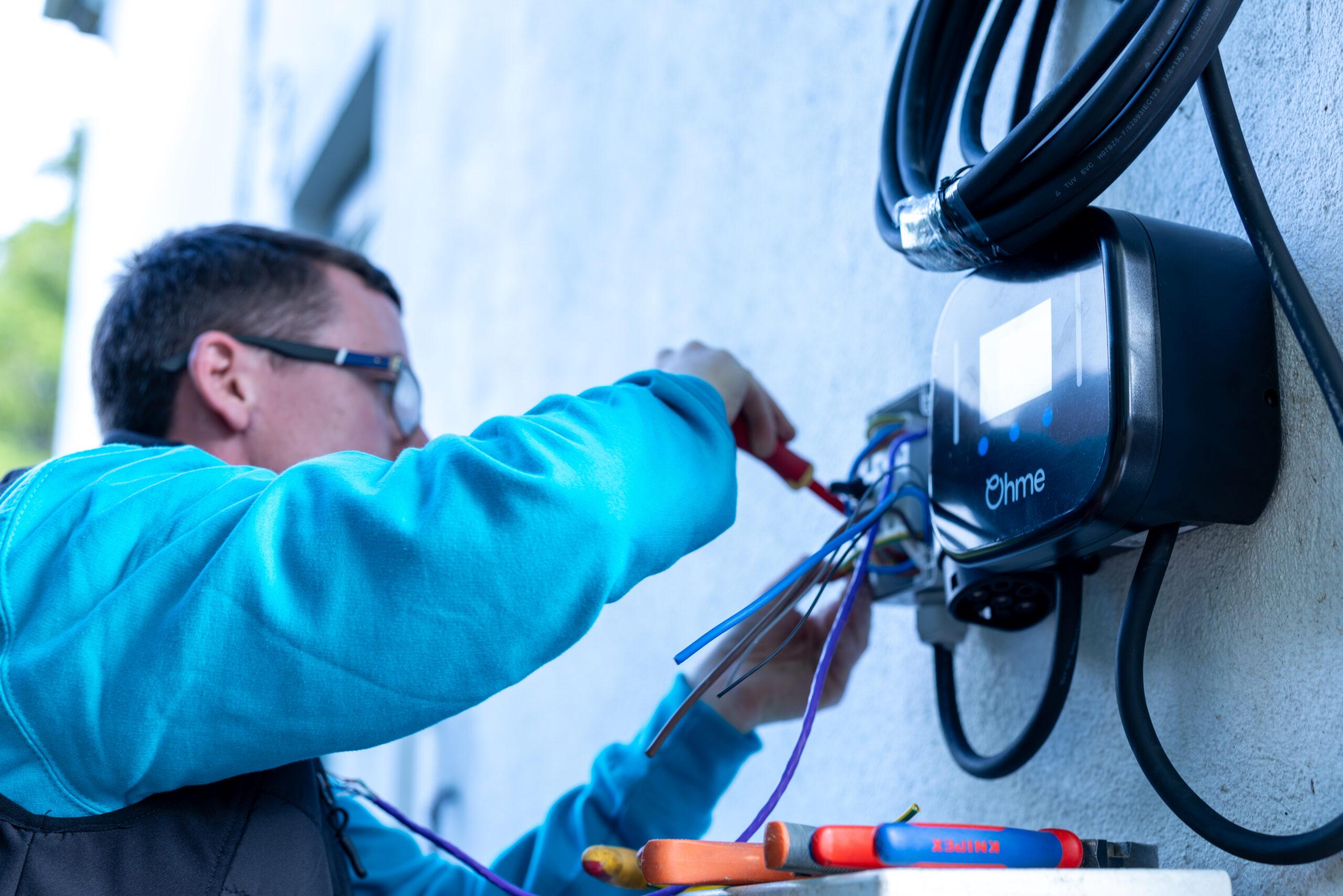 solar technician using tools on ohme power unit